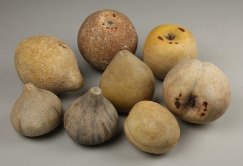 Acht stenen vruchten: appel, peer, sinaasappel, twee vijgen, perzik, abrikoos en citroen